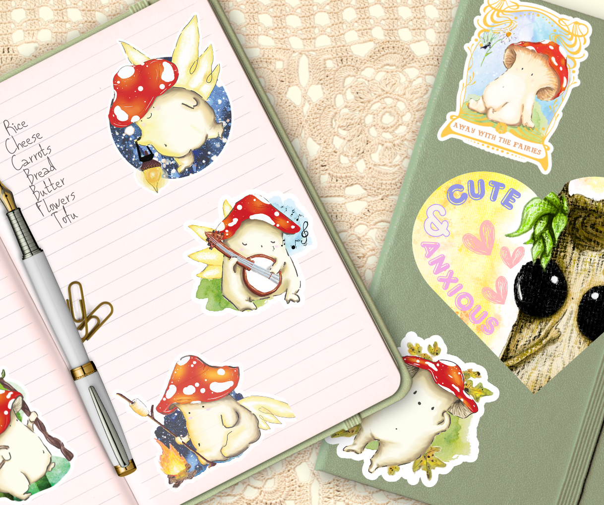 image shows two sage green journals one open and one closed, stuck across the pages and cover of the closed journal is an arrangement of stickers. inside the lined page of the open journal is a short handwritten shopping list, a white fountain pen and two brown paperclips. the journals are laid on top of a cream macrame table cloth