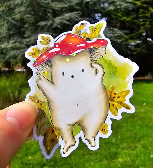 a holographic vinyl sticker of a fly agaric toadstool mushroom laying down on moss and leaves pointing up to the sky, cloud spotting