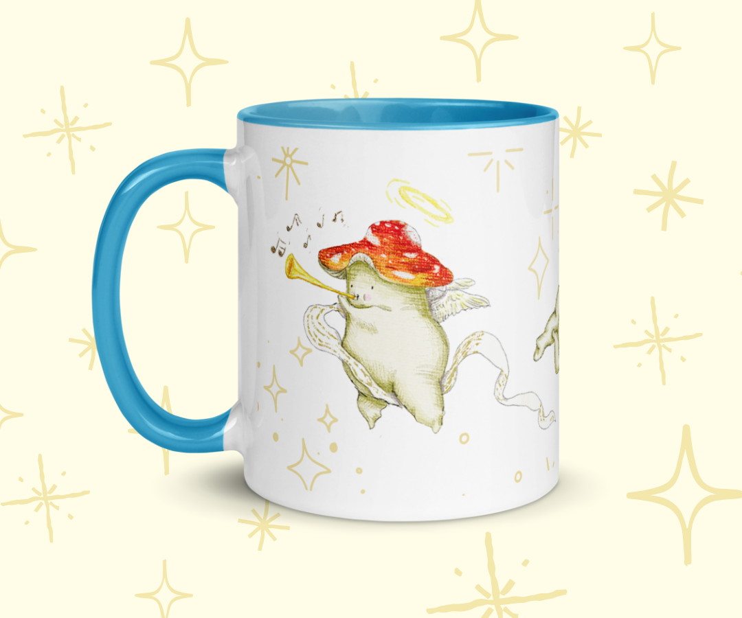 image shows a white ceramic mug which is blue on the uinside, and the handle. The design features illustrations of cherub mushrooms playing instruments and flying amongst a starry backdrop. The mug is imposed in front of a cream background with star graphic details