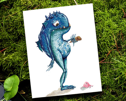 art print placed on a mossy riverbank. art print features a mystical fantasy creature, who is blue, with small wings and crystal points coming from their head. he looks down hopelessly at the ice cream that has just fallen to the ground from his cone.