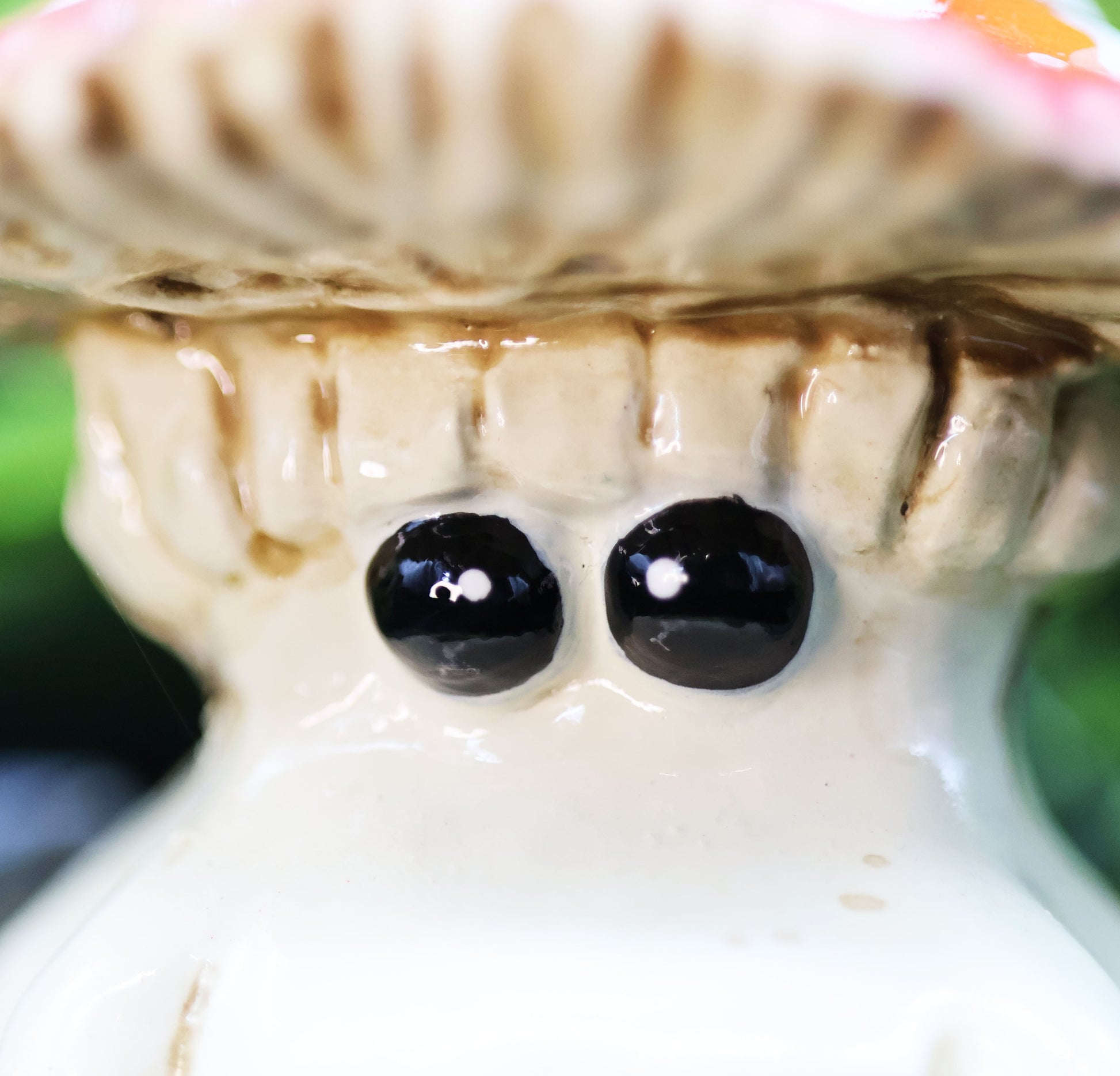 Close-up of a fly agaric mushroom  figurine with tiny black eyes 