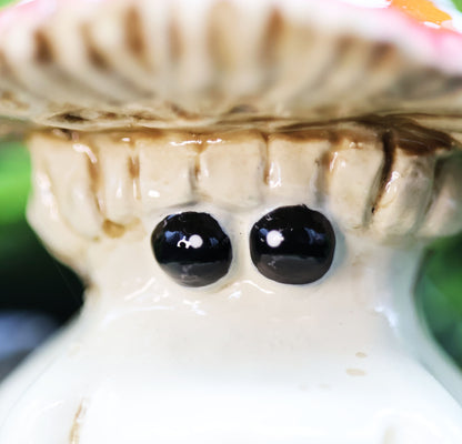 Close-up of a fly agaric mushroom  figurine with tiny black eyes 