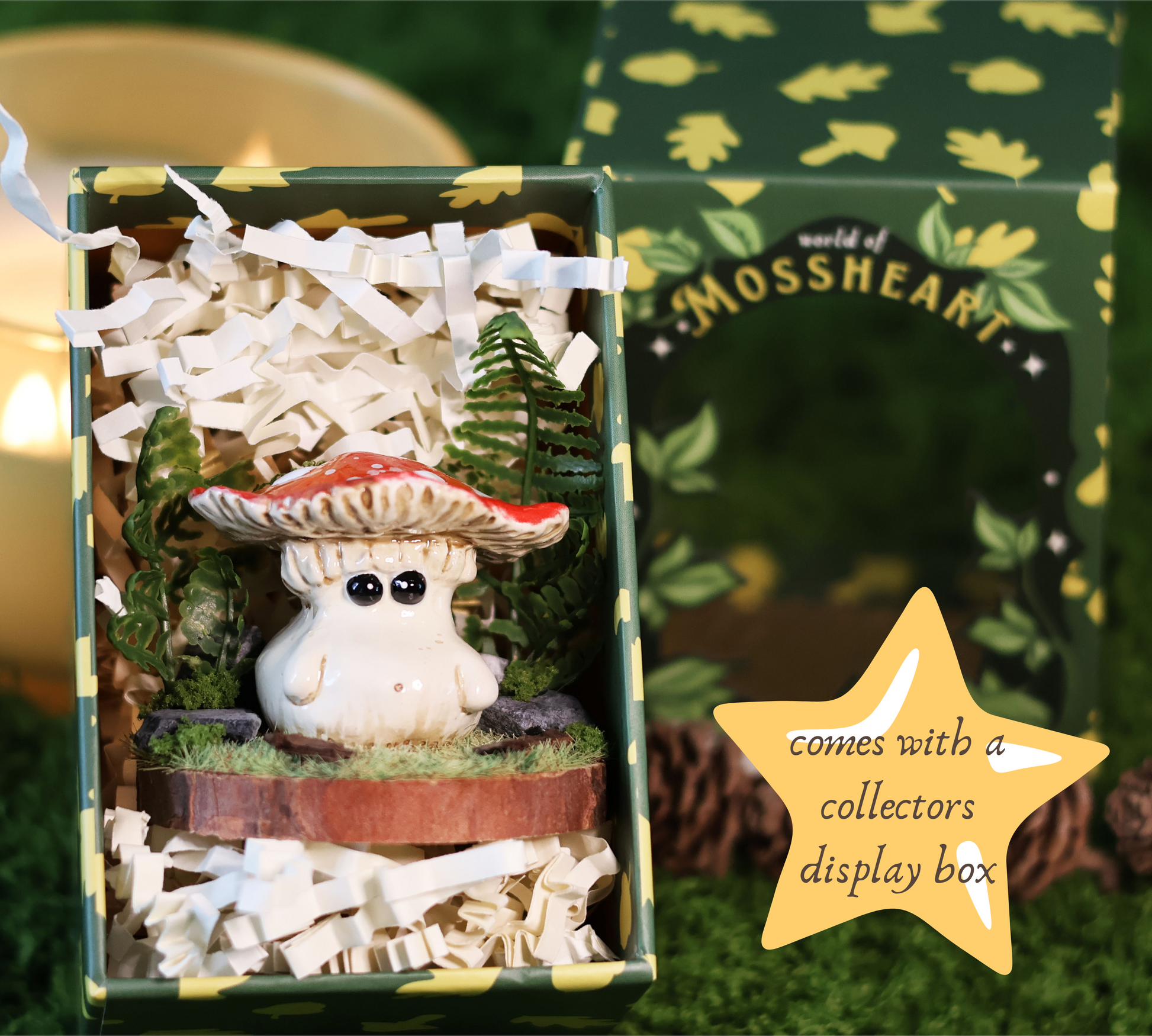 Adorable fly agaric mushroom figurine with a colourful red cap placed on a wooden base surrounded by a diorama of plants is placed inside a collectors display box filled with luxury packaging